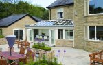 A glass roof extension from the outside with a view of the patio.