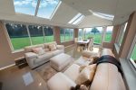 A T-shaped conservatory with white interior and furniture.